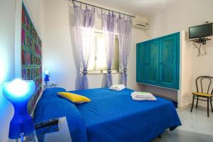 a bedroom with a blue bed and a window at Villa Anastasia-Lampedusa in Lampedusa
