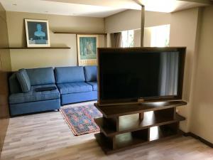 un soggiorno con divano blu e TV a schermo piatto di Hamburgo 29 a Città del Messico