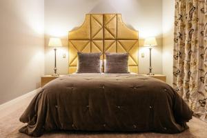 a bedroom with a large bed with two lamps at The Lodge at Mudbrick in Oneroa
