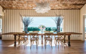 uma sala de jantar com uma mesa e cadeiras e um lustre em The Lodge at Mudbrick em Oneroa