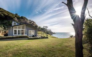 a house with a view of the ocean at Circular Bay in Awaroa
