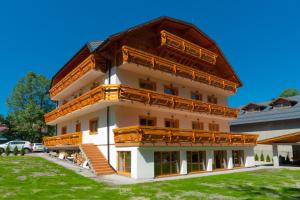 duży biały budynek z brązowym dachem w obiekcie Willa Alpejska w Wiśle