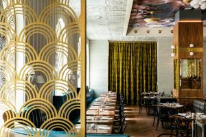 a dining room with tables and chairs and a yellow and white wallpaper at Hotel Bijou - Union Square in San Francisco