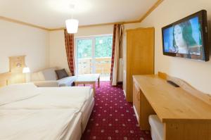 a hotel room with two beds and a flat screen tv at Willa Alpejska in Wisła