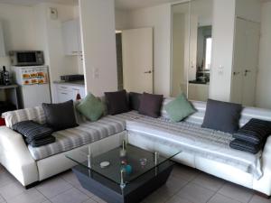 una sala de estar con un sofá y una mesa en Appartement F3 avec Parking privée, en Saint-Priest