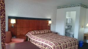 um quarto de hotel com uma cama e uma cadeira em Monterey Fairgrounds Inn em Monterey