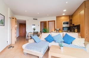 パラモスにあるAcogedor apartamento "La Fosca" Palamós, 5 min de la playaのリビングルーム(白いソファ、青い枕付)