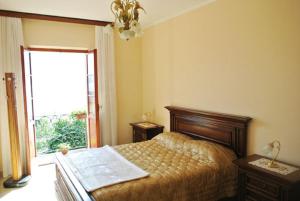 a bedroom with a bed and a large window at Casa Farfalla in Cannobio
