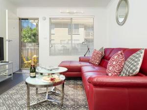 a living room with a red couch and a table at Understated Elegance Affordable Luxury in Albury