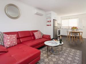 a living room with a red couch and a table at Understated Elegance Affordable Luxury in Albury