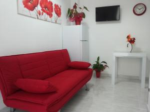 a red couch in a living room with red flowers at Appartamento Tulipano Rosso in Trapani