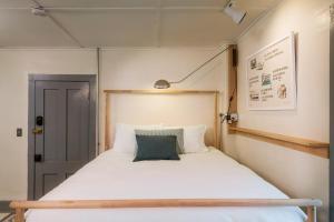 a small bedroom with a bed with white sheets at The Deers Head Inn Tavern in Elizabethtown