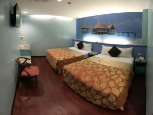 a hotel room with two beds and a balcony at Klai Hotel in Kaohsiung +31 photos