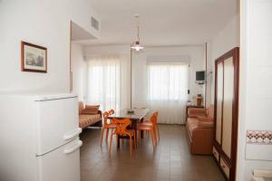 a kitchen and living room with a table and chairs at Apparthotel Residence Riviera dei Cedri in Santa Maria del Cedro