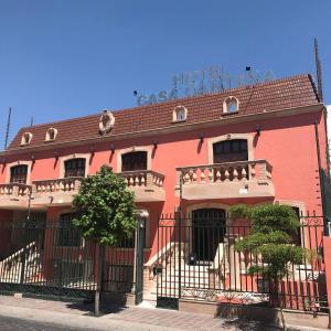 un edificio rosa con una valla negra delante de él en Hotel Casa Cantera, en León