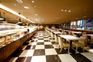 a restaurant with a checkered floor and tables and chairs at Kindness Hotel - Sandou II in Kaohsiung