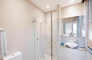 ein weißes Badezimmer mit Dusche und Waschbecken in der Unterkunft Quest Canberra in Canberra + 12 Fotos