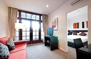una camera d'albergo con letto e TV di Quest Canberra a Canberra