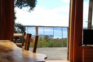 a dining room table with a view of a balcony at Peppermint Ridge Retreat in Woodbridge