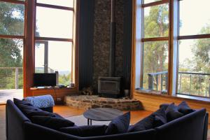 a living room with couches and a fireplace with windows at Peppermint Ridge Retreat in Woodbridge