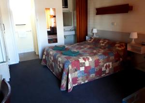 um quarto de hotel com uma cama e um espelho em Bordertown Motel em Bordertown