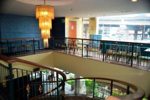 a staircase in a restaurant with tables and chairs at Hotel Caliber in Kuala Lumpur