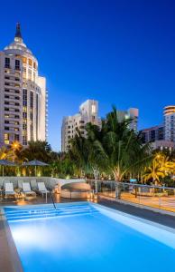 a swimming pool with a city skyline in the background at Hyatt Centric South Beach Miami in Miami Beach