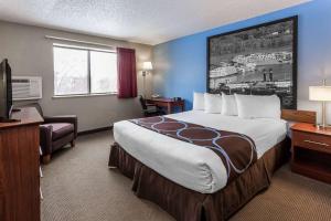 a hotel room with a large bed and a television at Super 8 by Wyndham Dubuque in Dubuque +12 photos