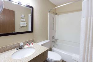 Super 8 by Wyndham Dubuque في دوبوك: حمام مع حوض ومرحاض وحوض استحمام