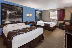 a hotel room with two beds and a television at Super 8 by Wyndham Dubuque in Dubuque