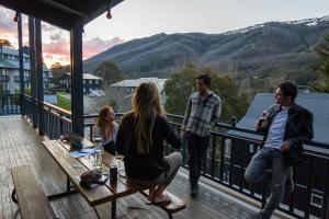 a group of people standing on the deck of a house at YHA Thredbo in Thredbo