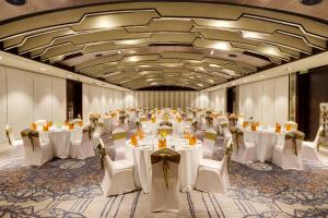 un salón de banquetes con mesas blancas y sillas en Novotel Kochi Infopark, en Kochi