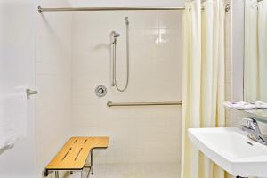 a bathroom with a shower and a sink and a bench at Knights Inn Jacksonville at Dix Ellis Trail in Jacksonville +6 photos