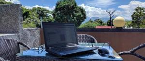 a laptop computer sitting on a glass table with headphones at Anabelle Residence in Dumaguete