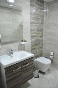 a bathroom with a sink and a toilet and a mirror at Nova Citrus Otel in Siğacık