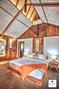 a bedroom with a large bed and wooden walls at Apalagi Villas in Gili Air