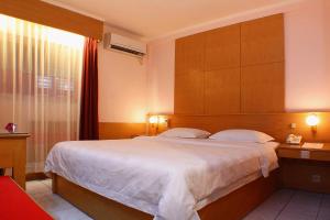a bedroom with a large bed and a window at Hotel Hangtuah in Padang