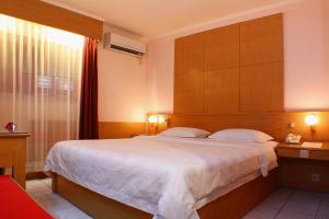- une chambre avec un grand lit et une fenêtre dans l'établissement Hotel Hangtuah, à Padang