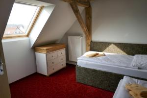 een slaapkamer op zolder met 2 bedden en een raam bij Ferienhof Radlerslust in Großkoschen