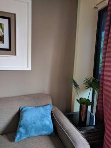 a couch with a blue pillow and a table at Anabelle Residence in Dumaguete