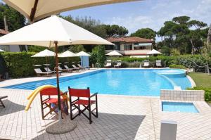 a swimming pool with two chairs and an umbrella at Hotel Bristol in Tirrenia