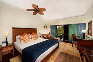 a bedroom with a bed and a ceiling fan at The Zuri Kumarakom Kerala Resort & Spa in Kumarakom