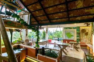 a living room with tables and chairs and a surfboard at Olives The Boutique Resort in Kalpetta