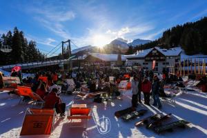 un groupe de personnes assises dans la neige avec du matériel de ski dans l'établissement Hotel Fortini, à Madonna di Campiglio