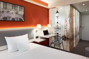 a hotel room with a bed and a desk with a laptop at Best Western Hotel Leipzig City Centre in Leipzig