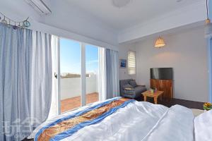 a bedroom with a bed and a large window at 夏日澄藍The Charming Land in Baisha +34 photos