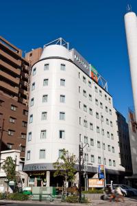 un edificio blanco con un cartel encima en Sotetsu Fresa Inn Tokyo-Toyocho en Tokio