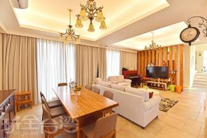 a living room with a table and a dining room at 夏日澄藍The Charming Land in Baisha