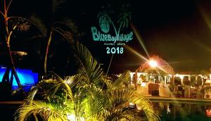 a sign for a party at night with palm trees at Blue Bay Village in Watamu