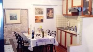 a kitchen with a table and chairs in a kitchen at Apartman i Sobe Čule Cres in Cres